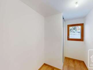 This bright and airy room features a large window offering scenic views of the snowy landscape outside.
