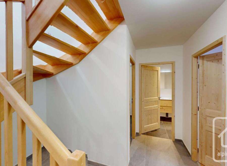 Ascend to the upper levels of this charming property via a beautifully crafted wooden staircase, featuring natural wood treads and a sturdy banister.
