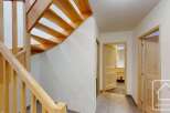 Ascend to the upper levels of this charming property via a beautifully crafted wooden staircase, featuring natural wood treads and a sturdy banister.