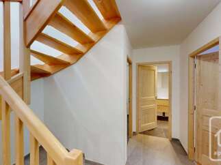 Ascend to the upper levels of this charming property via a beautifully crafted wooden staircase, featuring natural wood treads and a sturdy banister.