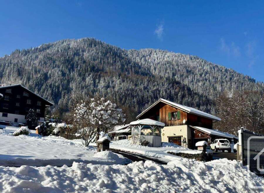 Experience the charm of a winter wonderland with this picturesque property nestled against a snow-covered mountain.