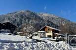 Experience the charm of a winter wonderland with this picturesque property nestled against a snow-covered mountain.