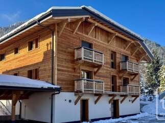 Experience the charm of alpine living in this stunning wooden chalet, nestled amidst snow-covered mountains.