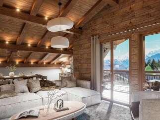 Experience luxurious alpine living in this stunning chalet, featuring a spacious open-plan living and dining area with a vaulted wooden beam ceiling and panoramic mountain views.