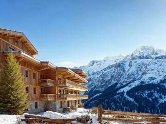 Experience luxury mountain living in this stunning wooden chalet, perfectly situated against a backdrop of majestic snow-capped peaks.