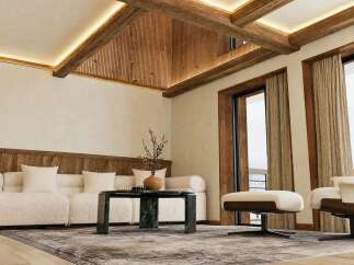 Experience luxury mountain living in this stunning living room, featuring exposed wooden beams and ambient lighting for a cozy yet sophisticated atmosphere.