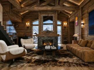 Experience luxury mountain living in this stunning chalet, featuring a grand stone fireplace and vaulted wooden ceilings.