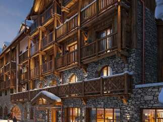 Experience luxury mountain living in this stunning chalet-style hotel, featuring rustic wooden architecture and stone accents.