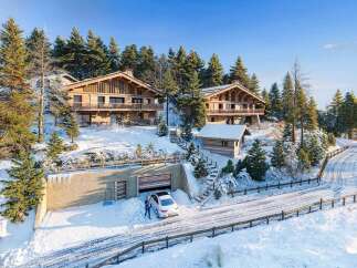 Experience luxurious mountain living in this stunning wooden chalet nestled amidst snow-covered pines.