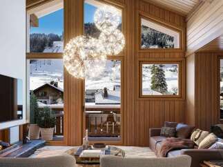 Experience luxury mountain living in this stunning chalet, featuring a modern fireplace and a large flat-screen TV.