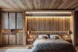Experience rustic luxury in this master bedroom, featuring a stunning wooden accent wall behind the bed, complemented by warm ambient lighting.