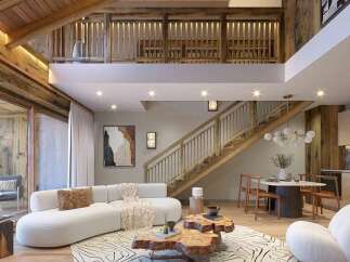Experience luxurious mountain living in this stunning chalet-style apartment, featuring a spacious open-plan living area with a modern kitchen and dining space.