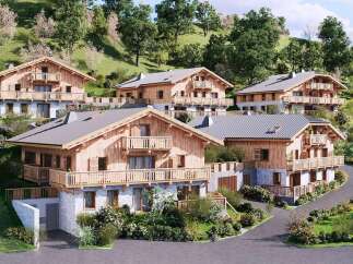 Discover these stunning alpine chalets nestled on a lush green hillside, offering breathtaking mountain views.