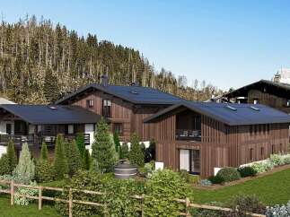 Experience luxury mountain living in this stunning chalet, featuring modern architecture with warm wooden exteriors and dark metal roofs.