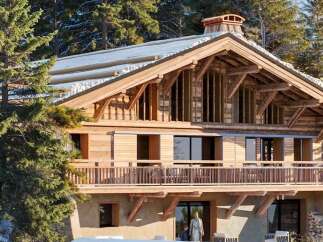 Experience luxury mountain living in this stunning chalet, nestled amidst snow-dusted pine trees.