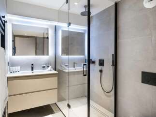 Experience modern luxury in this beautifully appointed bathroom, featuring a sleek vanity with integrated lighting and a spacious walk-in shower.