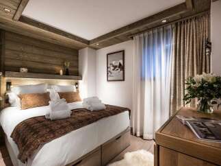 Experience ultimate comfort in this beautifully appointed bedroom, featuring a luxurious king-size bed adorned with plush pillows and crisp white linens.