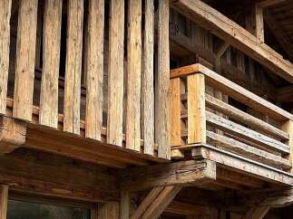 Experience rustic charm with this stunning wooden balcony, featuring robust timber beams and a classic railing design.