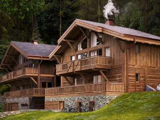 Experience luxury mountain living in this stunning wooden chalet nestled amidst a lush forest.