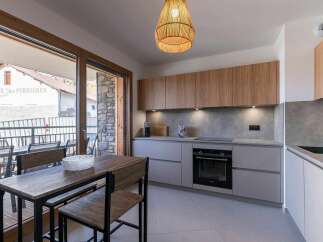 Experience modern living in this stylish kitchen, featuring sleek grey cabinetry and warm wooden upper cabinets.