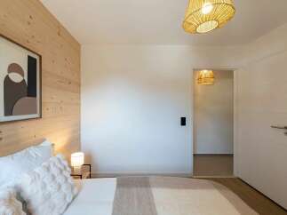 Experience modern comfort in this beautifully appointed bedroom, featuring a cozy bed adorned with plush pillows and a soft throw.