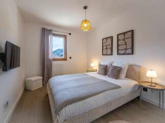 Experience comfort and style in this beautifully appointed bedroom, featuring a plush bed adorned with soft linens and decorative pillows.