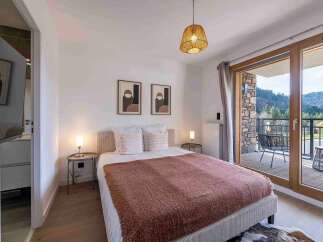 Experience ultimate comfort in this beautifully appointed bedroom, featuring a plush bed adorned with soft linens and a cozy throw.