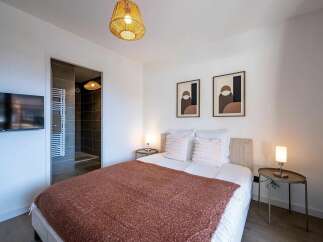 Experience comfort and style in this beautifully appointed bedroom, featuring a plush bed adorned with soft pillows and a cozy throw.