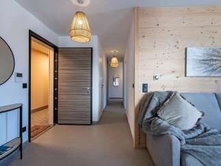 Step into this inviting entryway featuring a modern wood-grain door and a stylish woven pendant light.