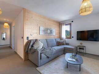 Experience modern mountain living in this beautifully appointed living space, featuring a comfortable sectional sofa and a striking piece of wall art.