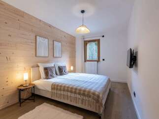 Experience cozy mountain living in this charming bedroom, featuring a beautifully paneled wood accent wall that adds warmth and character.