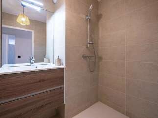 Experience modern comfort in this beautifully appointed bathroom, featuring a sleek vanity with ample storage and a pristine white sink.