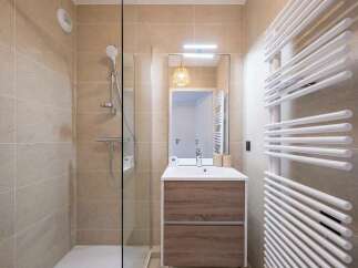 Experience modern comfort in this beautifully appointed bathroom, featuring a sleek glass-enclosed shower and a stylish vanity with ample storage.