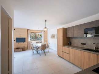 Experience modern living in this beautifully appointed apartment, featuring a sleek, integrated kitchen with ample cabinetry and a spacious dining area perfect for family meals.