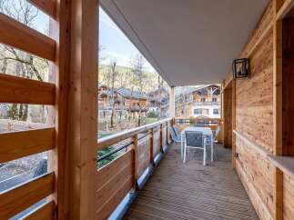 Enjoy the fresh mountain air from this charming wooden balcony, complete with a dining set for al fresco meals.