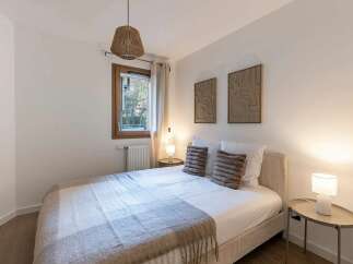 This cozy bedroom features a comfortable bed adorned with plush pillows and a soft throw blanket, creating an inviting atmosphere.