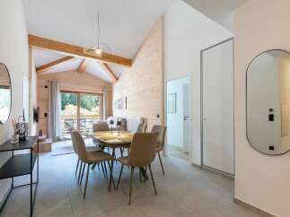 Experience modern alpine living in this beautifully appointed apartment, featuring a spacious dining area with comfortable seating perfect for family meals.