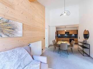 Experience modern living in this beautifully appointed apartment, featuring a spacious open-plan living area with a cozy sofa and a striking abstract artwork.