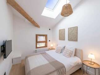 Experience modern comfort in this beautifully appointed bedroom, featuring a vaulted ceiling with a skylight that floods the space with natural light.