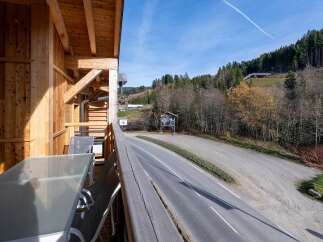 Enjoy breathtaking mountain views from your private balcony, complete with a glass-top table and comfortable seating.