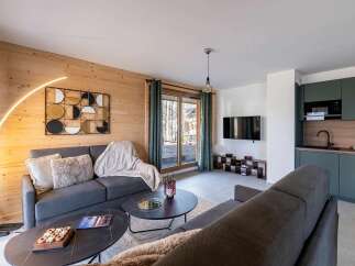Experience modern living in this beautifully appointed apartment, featuring a sleek, dark green kitchen with integrated appliances and ample counter space.