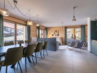 This spacious open-plan living area features a large dining table with comfortable seating, perfect for family meals.