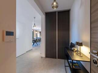 Step into a modern entryway featuring a sleek console table adorned with decorative lamps and a stylish entryway door.
