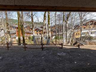 Experience the charm of alpine living in this stunning property, featuring traditional wooden chalets nestled amidst a serene forest landscape.
