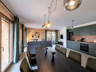 Experience modern living in this beautifully appointed apartment, featuring a spacious open-plan living area with a sleek dining table and comfortable seating.