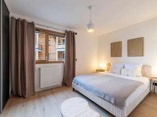 Experience comfort and style in this beautifully appointed bedroom, featuring a plush king-sized bed adorned with soft linens and decorative pillows.