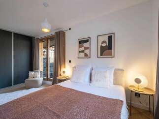 Experience comfort and style in this beautifully appointed bedroom, featuring a plush bed adorned with soft linens and decorative pillows.