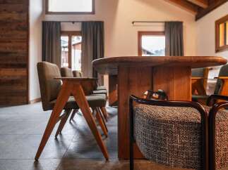 Experience rustic elegance in this dining area, featuring a stunning live-edge wooden table and comfortable upholstered chairs.