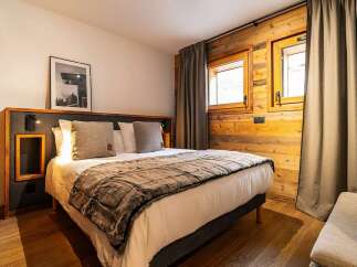 Experience cozy mountain living in this charming bedroom, featuring a plush king-size bed adorned with a luxurious faux fur throw.