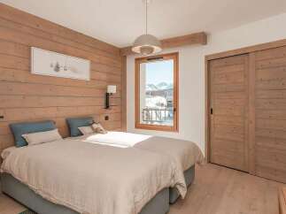 Experience cozy mountain living in this charming bedroom featuring two twin beds dressed in soft, neutral linens.